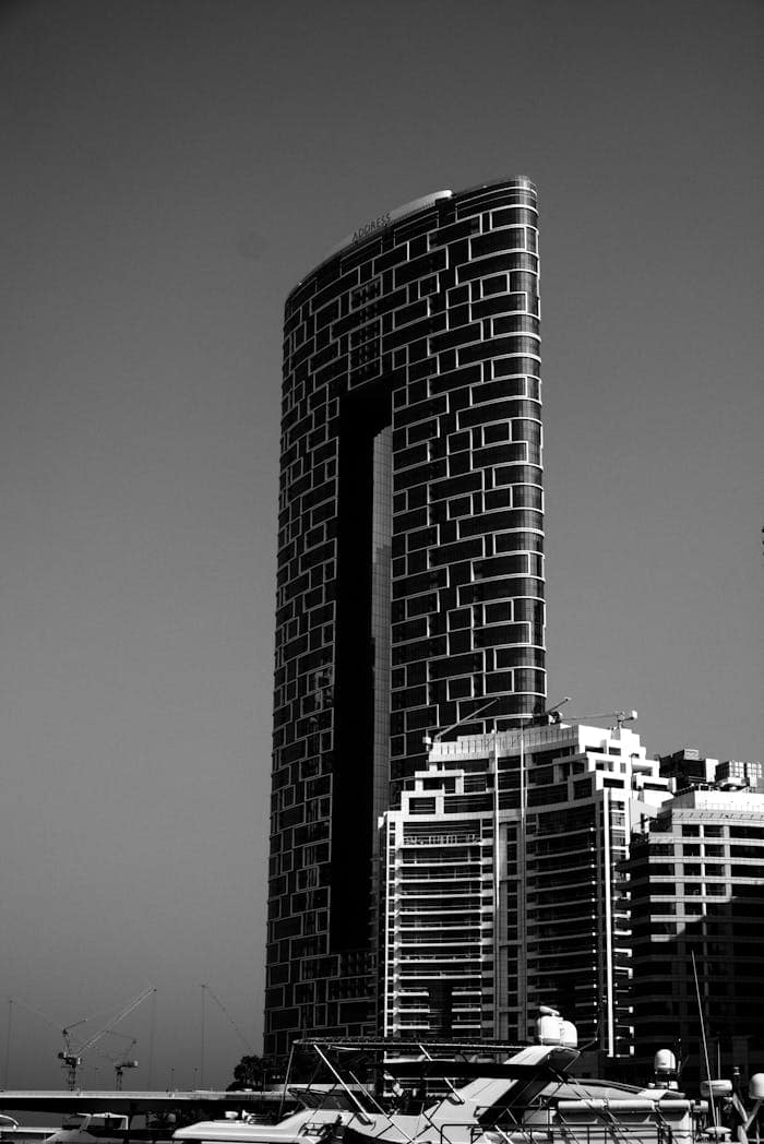 Mastering the First Impression: Your intriguing post title goes here Iconic skyscraper with geometric facade in Dubai Marina, captured in black and white.